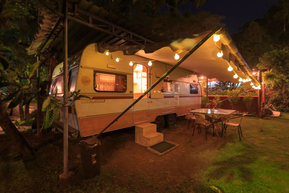 A warmly illuminated motorhome with outdoor seating creating a cozy vacation ambiance.