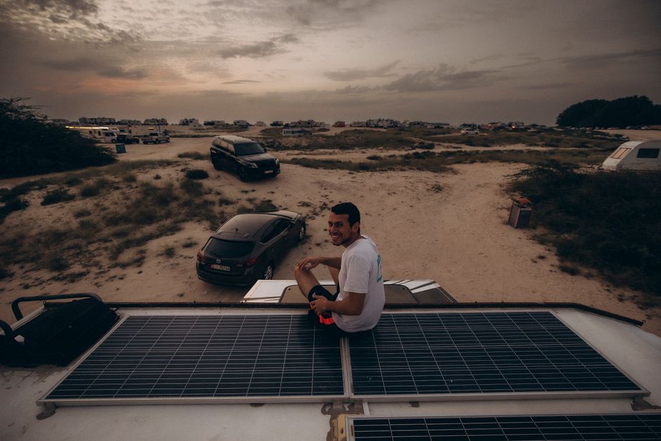Explore the serene desert landscape in Dubai at sunset with camping and solar panels.